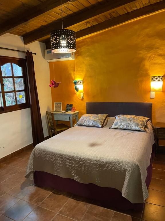 1 dormitorio con cama, mesa y ventana en Ama respira y vive en Salta
