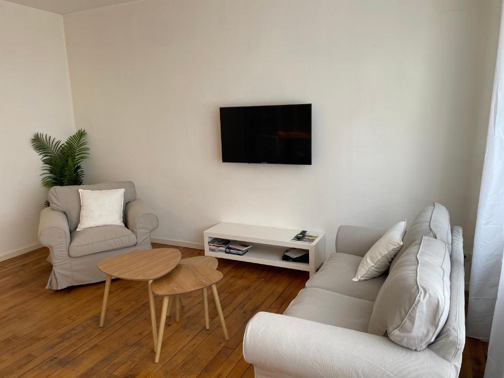 uma sala de estar com um sofá e uma mesa em Appartement en coeur de ville 2 personnes em Bort-les-Orgues