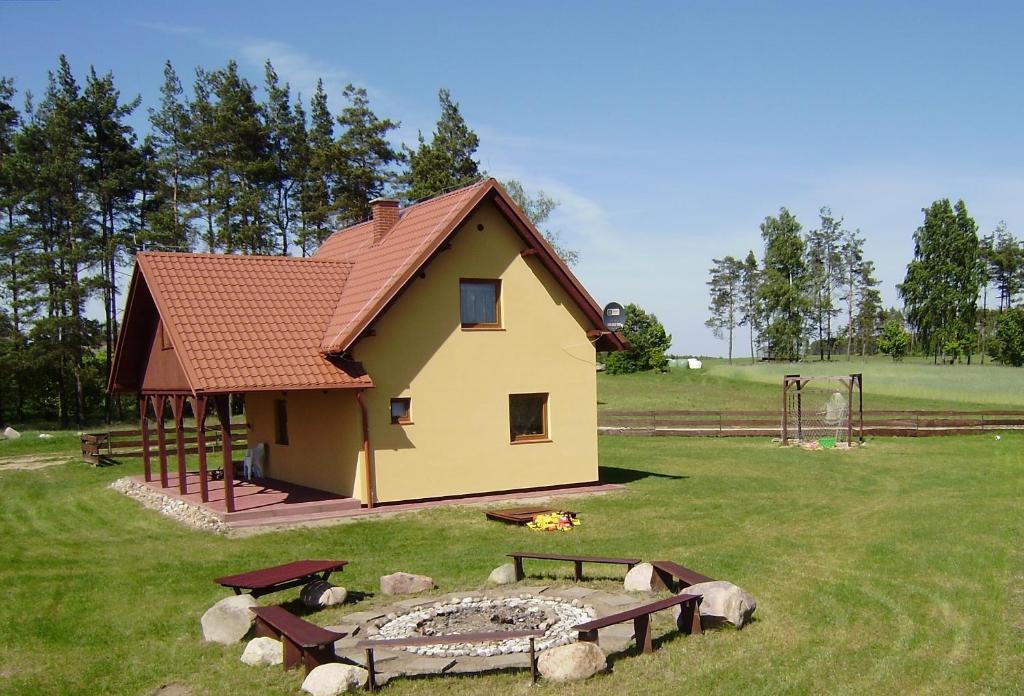 a small house with a fire pit in a yard at Kaszuby Dom W Wielu in Wiele