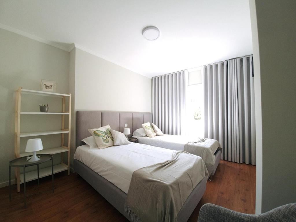 um quarto com 2 camas e uma janela em Sonetos - Guest House no Porto
