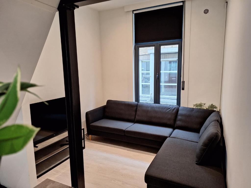 un soggiorno con divano e specchio di Huis ALNA 2 a Mechelen