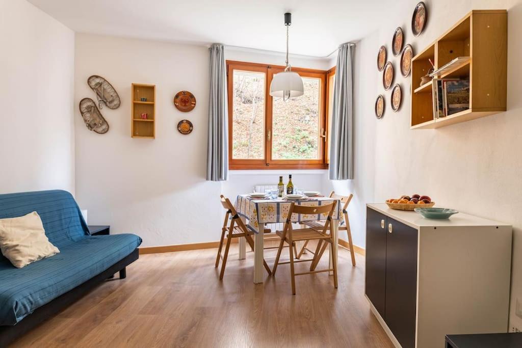 a living room with a blue couch and a table at Val di Luce Foemina RB in Abetone