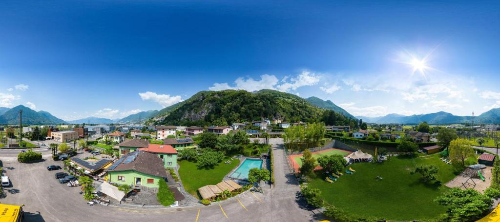 - une vue aérienne sur un complexe avec une montagne dans l'établissement Bamboohouse Motel Riazzino, à Riazzino