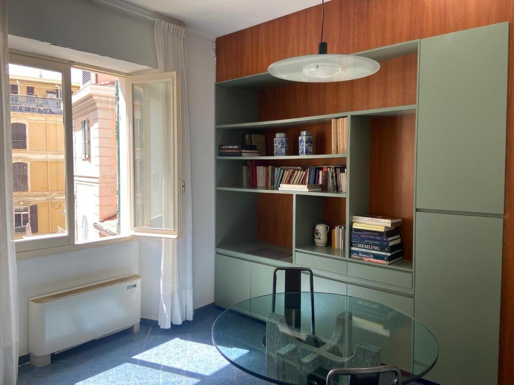 una camera con un tavolo in vetro e una finestra di Casa in Centro a Sanremo