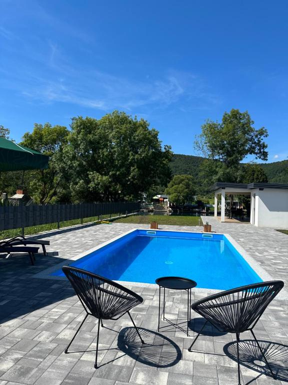 a swimming pool with two chairs and a table at Unavis Residence in Bihać