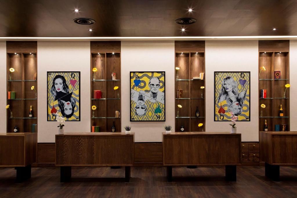a room with paintings on the walls and benches at St Giles London – A St Giles Hotel in London