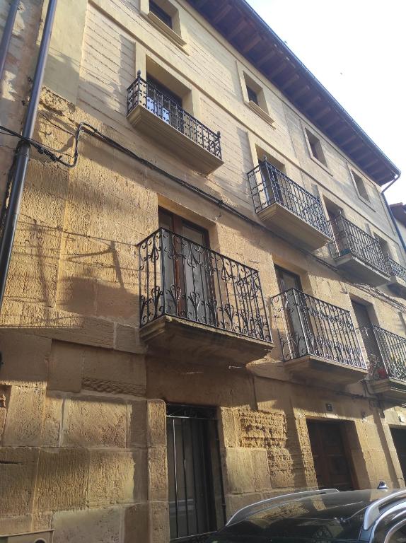 un edificio con balcones y un coche aparcado delante de él en Casa Moneo, en Briones