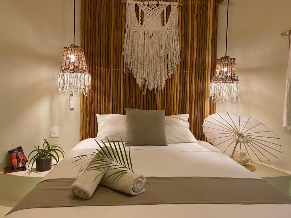 a bedroom with a large white bed with two lights at Isabella Boutique Hotel in Playa del Carmen