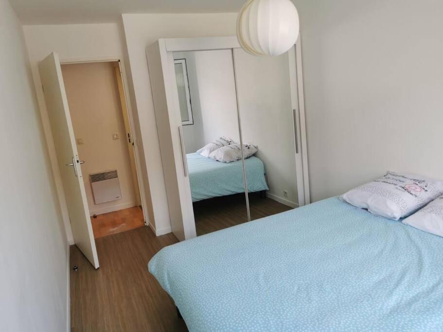 ein Schlafzimmer mit einem Spiegel und einem Bett darin in der Unterkunft Plage du Havre in Le Havre