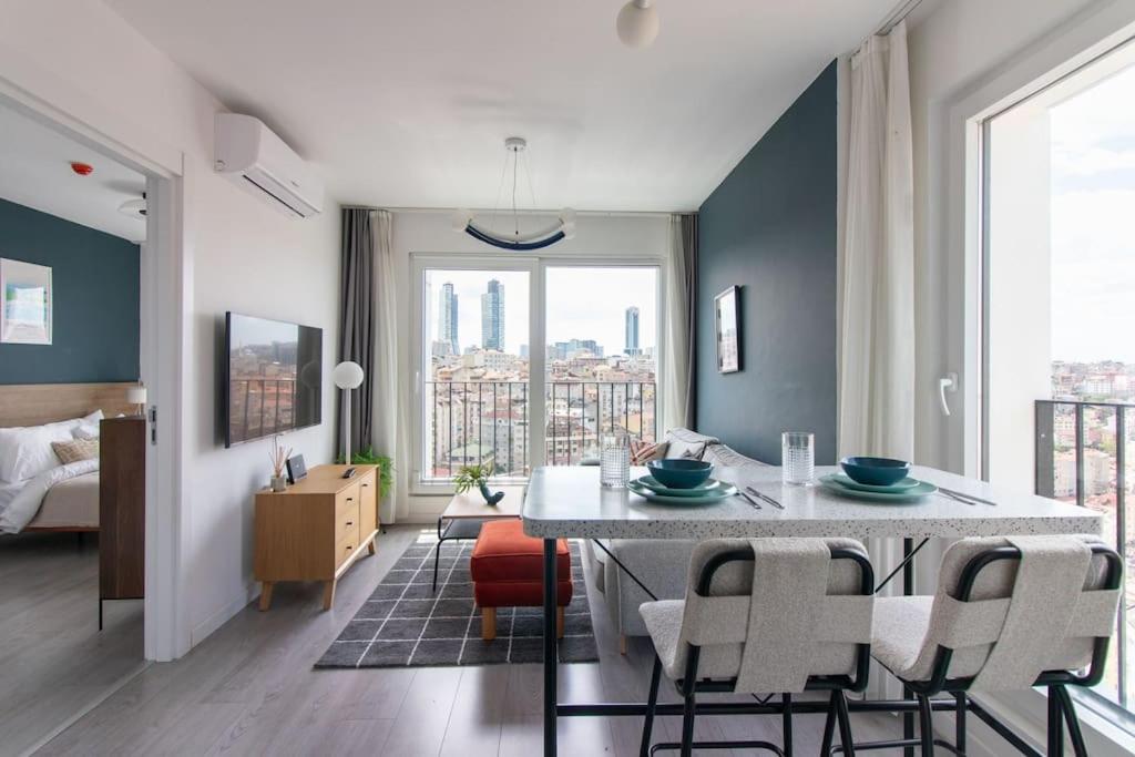 un comedor con mesa y sillas y un dormitorio en Sleek & Modern 1BR Corner Flat w Views + Parking #191, en Estambul