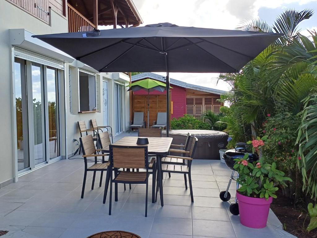 stół i krzesła z parasolem na patio w obiekcie F3 Le Carbet des Anges w mieście Le Carbet