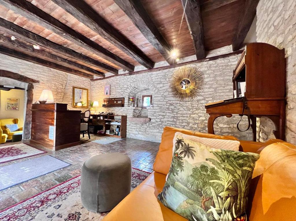 ein Wohnzimmer mit Sofa und Klavier in der Unterkunft Hôtel Les Vieilles Tours Rocamadour in Rocamadour