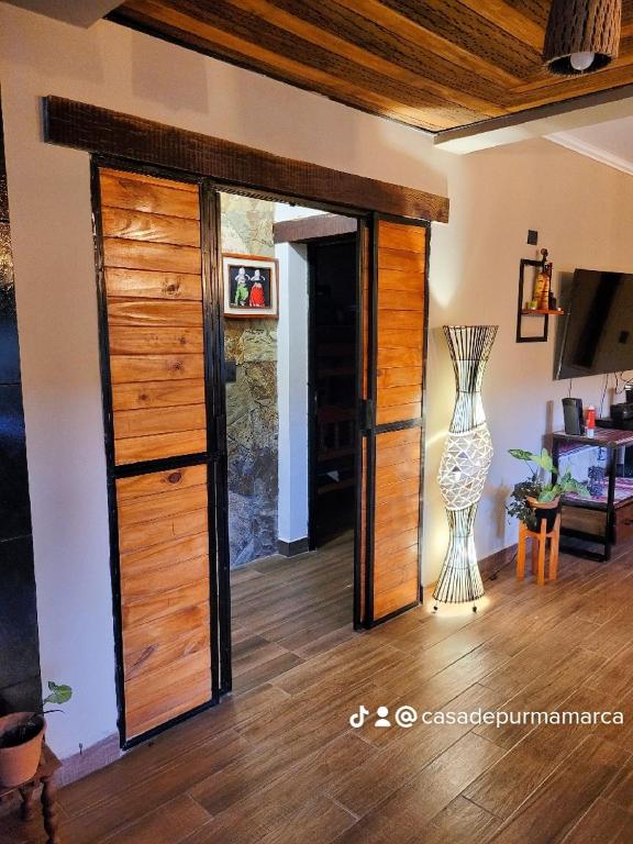 a room with a wooden door and a vase at CASA de PURMAMARCA in Purmamarca