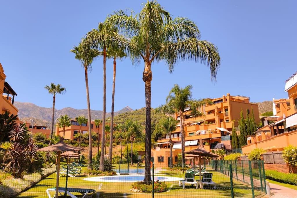 um resort com palmeiras e uma piscina em Bonito apartamento en Marbella con piscina em Marbella