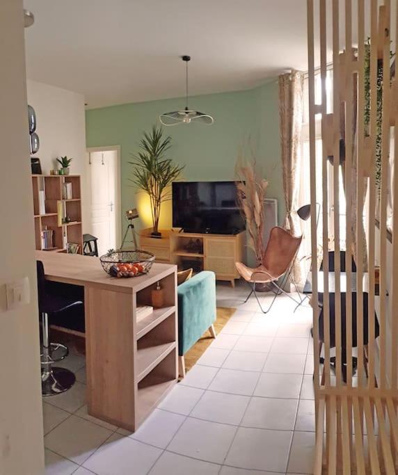 Il comprend un salon avec un bureau et une télévision. dans l'établissement L'Appart Aixois - au coeur de la ville - Location, à Aix-les-Bains