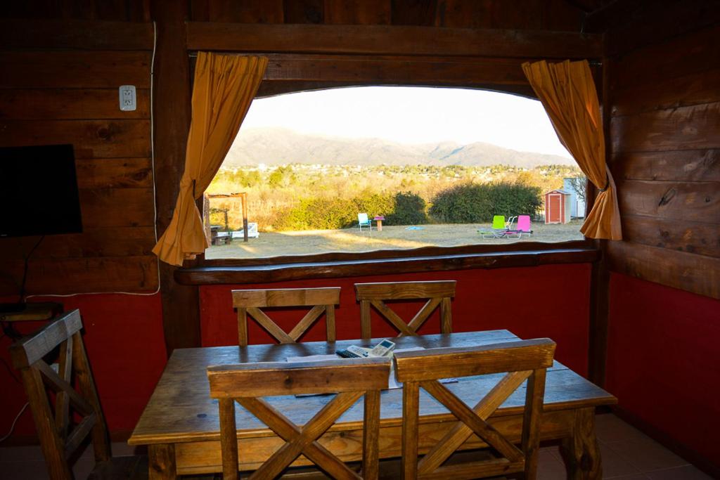 mesa y sillas en una habitación con ventana en cabañas santa catalina en Villa Giardino