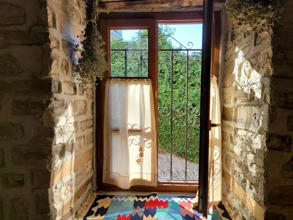 a window in a building with a curtain on it at Melodia - Harmony Heaven in Gjirokastër