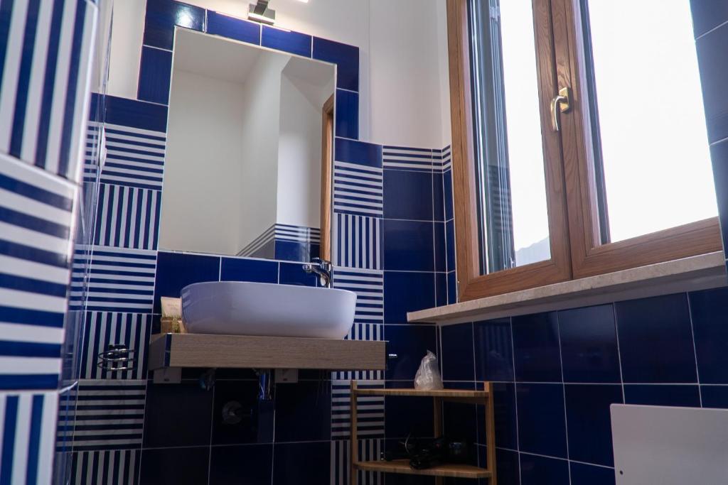 a blue tiled bathroom with a sink and a mirror at Mareterè in Vietri sul Mare
