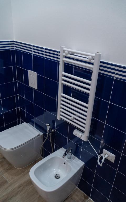a blue tiled bathroom with a toilet and a sink at Mareterè in Vietri sul Mare
