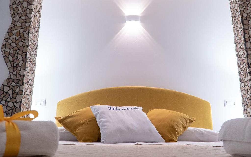 a bed with a yellow headboard with a light above it at Mareterè in Vietri sul Mare