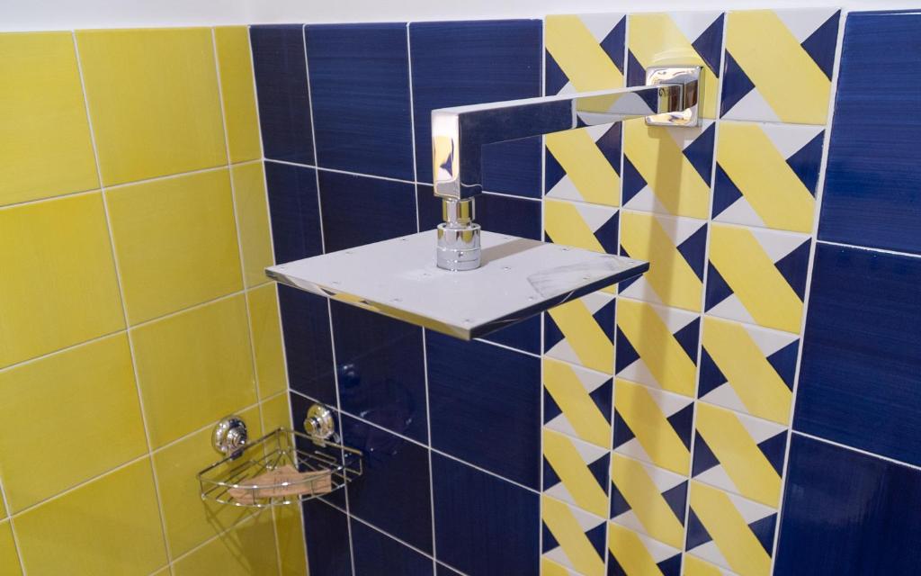 a bathroom with a blue and yellow tiled wall at Mareterè in Vietri sul Mare