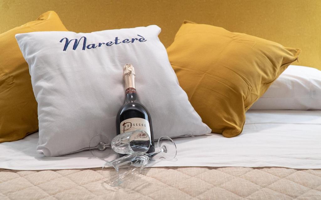 a bottle of wine sitting on top of a bed at Mareterè in Vietri sul Mare