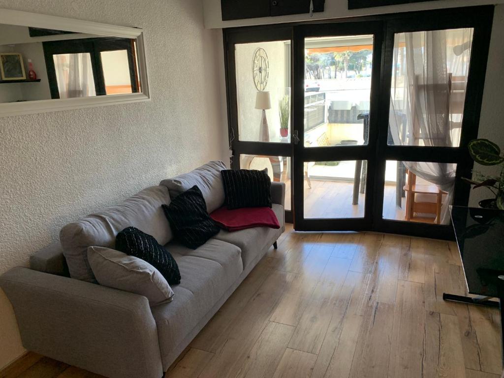 a living room with a couch in front of a door at L appartement de la plage in Le Barcarès