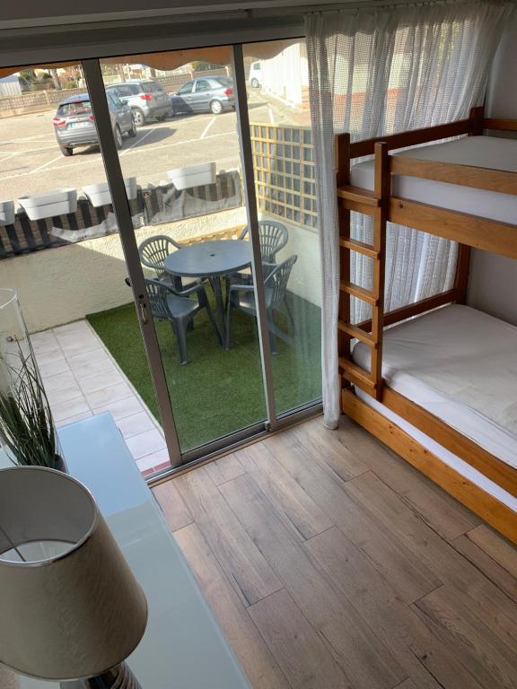 a room with a balcony with a table and chairs at L appartement de la plage in Le Barcarès