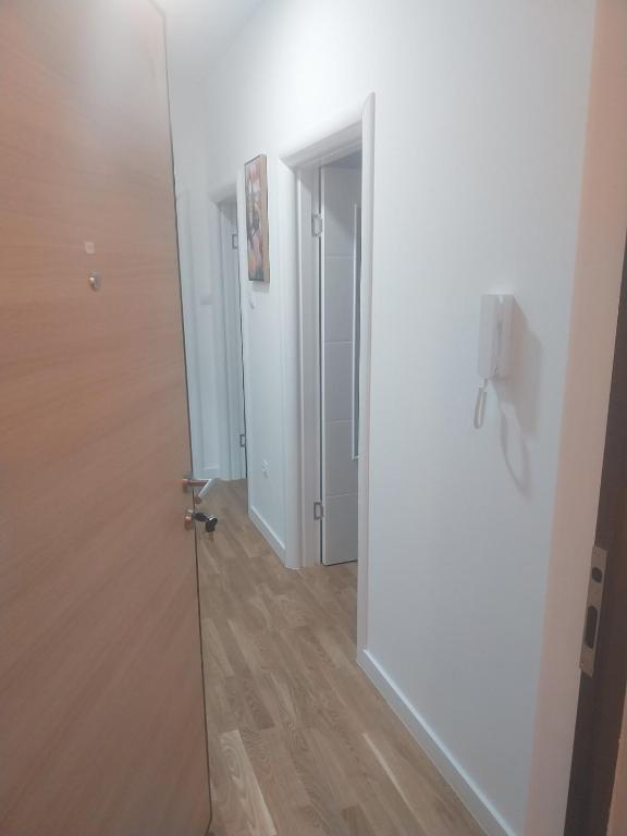 a hallway with a white door and a wooden floor at Milica in Trebinje