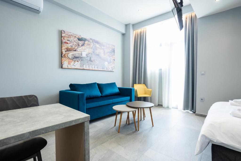 Aristotelous Downtown Suites في سلانيك: غرفة معيشة مع أريكة زرقاء وسرير