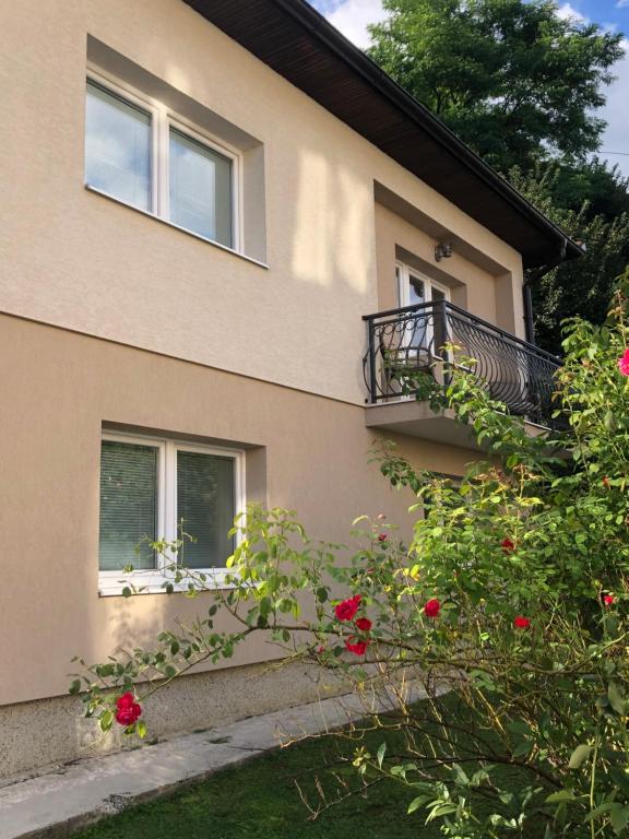 un edificio con balcone e rose rosse di fronte ad esso di Apartman Pionirska a Sarajevo