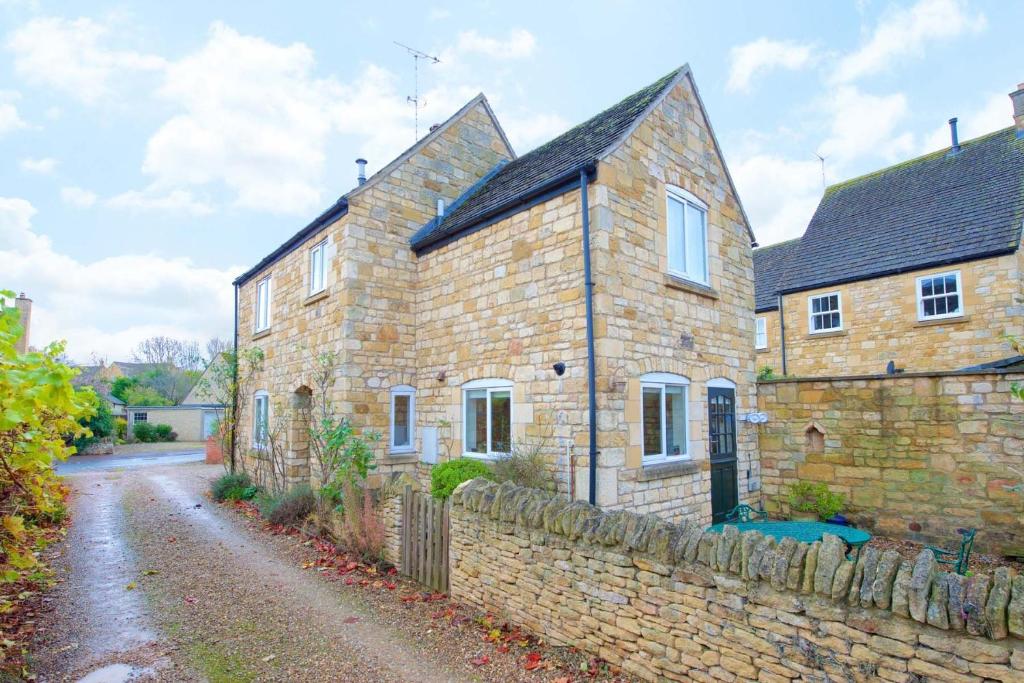 an old brick house with a stone wall at Badgers End in Chipping Campden