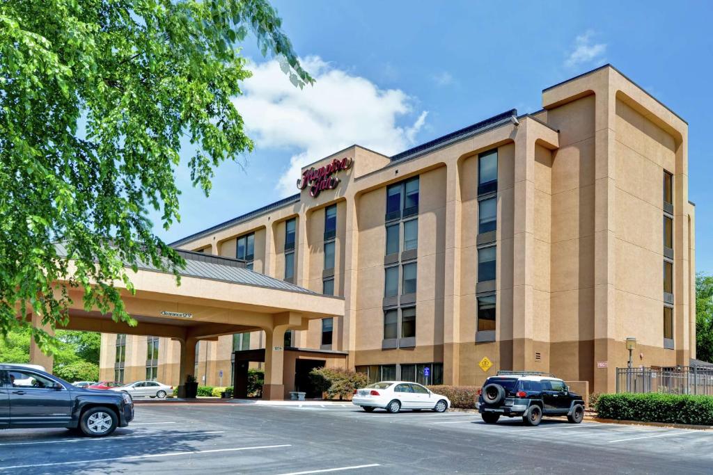 un hotel con coches estacionados en un estacionamiento en Hampton Inn Charlotte-Gastonia en Gastonia