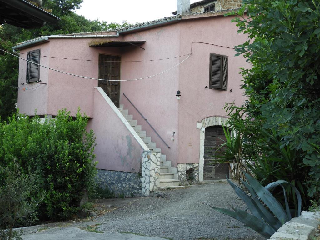a pink house with a staircase in front of it at HAPPY HOME in Orte