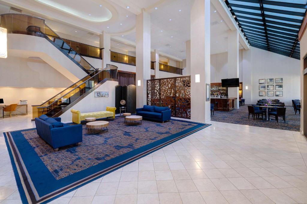 a lobby with blue couches and a staircase at Embassy Suites by Hilton Santa Clara Silicon Valley in Santa Clara