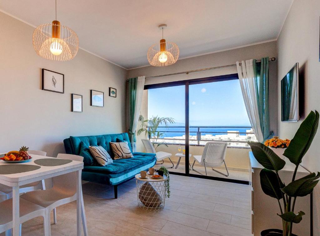 a living room with a blue couch and a view of the ocean at Paradise View Family Apartment in Adeje