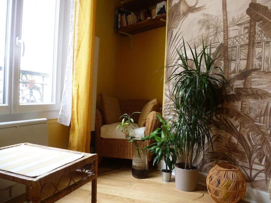 un salon avec des plantes en pot et un canapé dans l'établissement Cocon cosy & calme / Montmartre, à Paris
