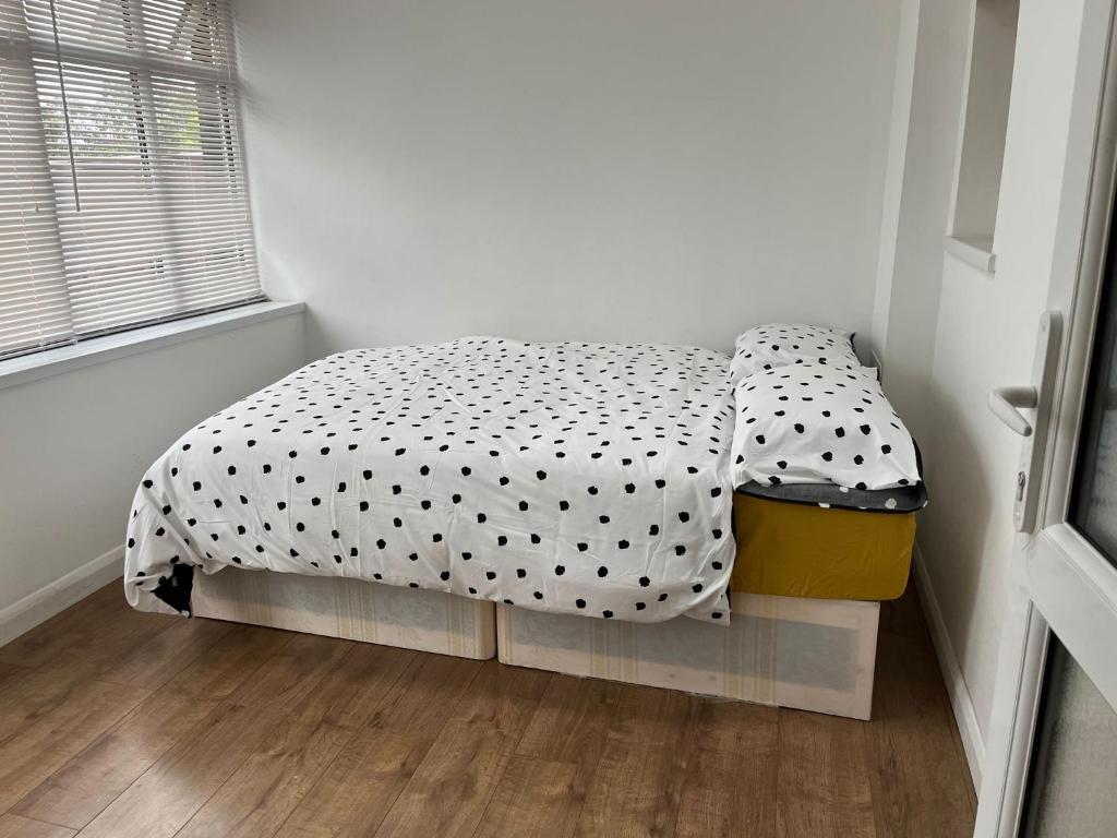 een kleine slaapkamer met een bed met polka dot-lakens bij 10 Valley Road, in Kent