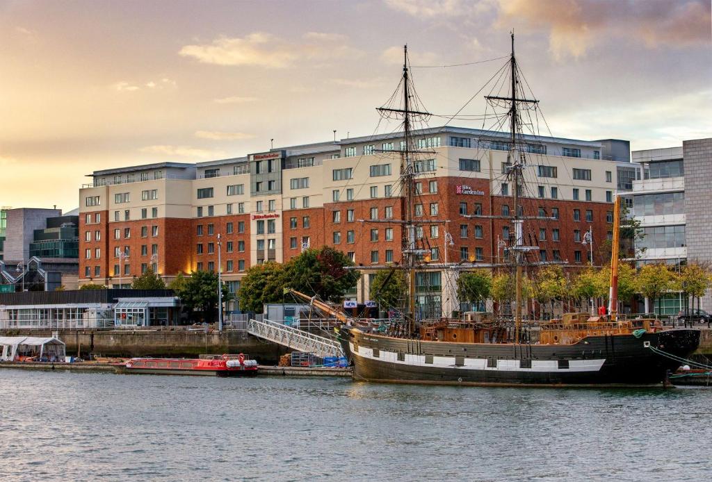 a boat sitting in the water in front of a building at Hilton Garden Inn Dublin City Centre in Dublin