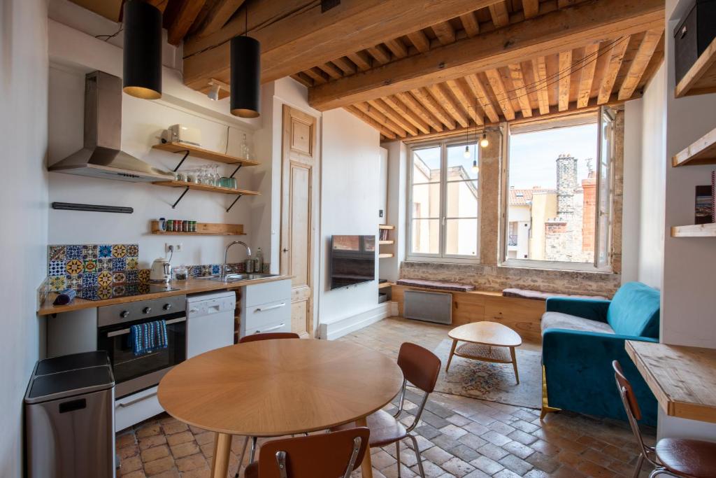 a kitchen and living room with a table and a couch at Nid de l'Opéra in Lyon