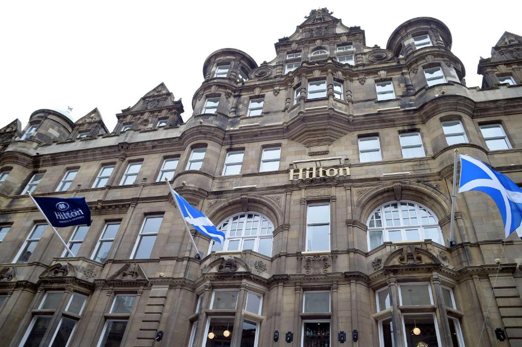 a building with flags in front of it at Hilton Edinburgh Carlton in Edinburgh