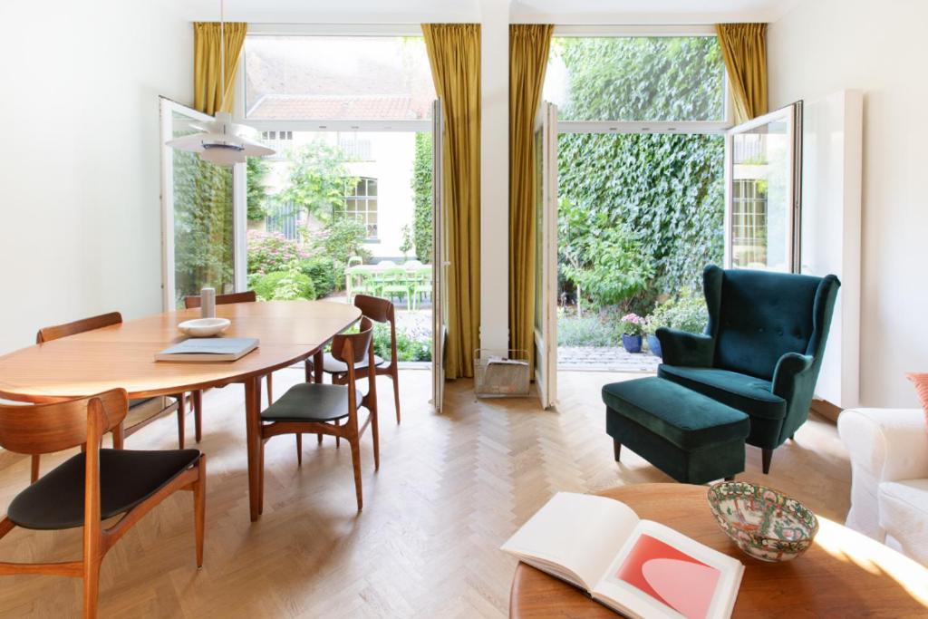 a living room with a wooden table and chairs at Pauline Loveling apartment with quiet garden and 2 bathrooms in Antwerp