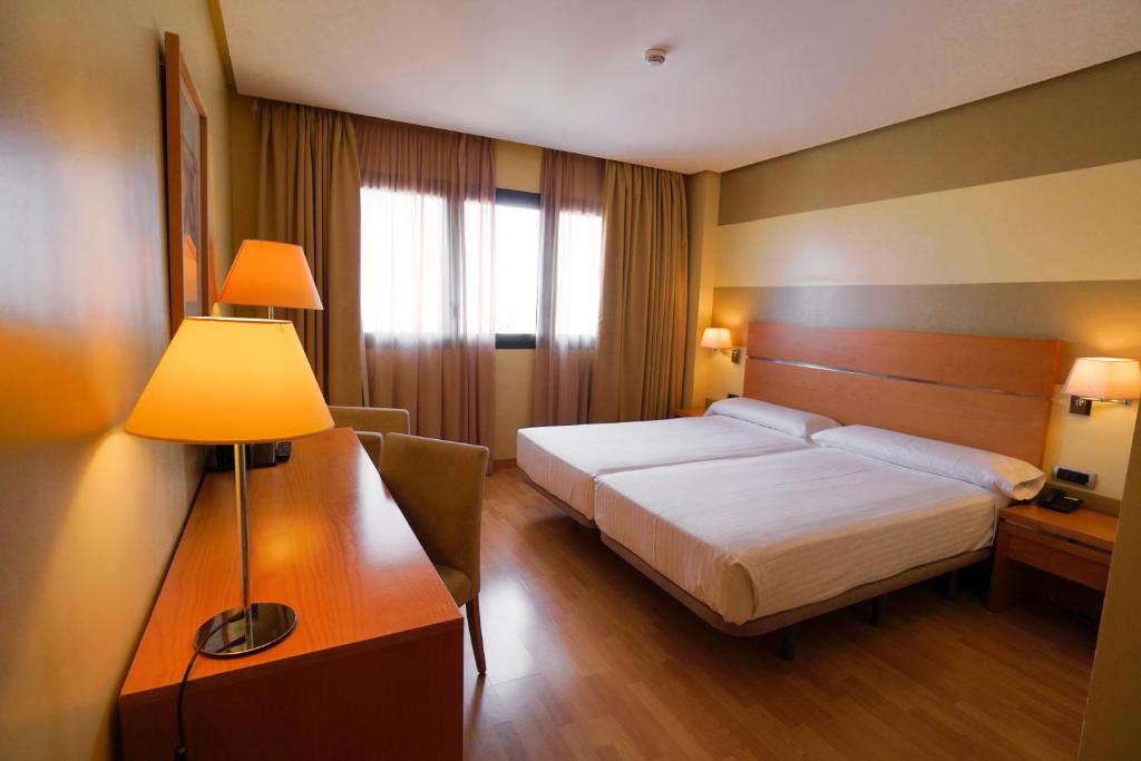 Habitación de hotel con cama y lámpara en Hotel Reston Valdemoro, en Valdemoro