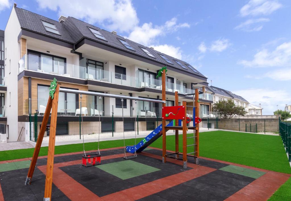 einen Spielplatz vor einem Gebäude in der Unterkunft Duerming Playa de Foz VUT in Foz