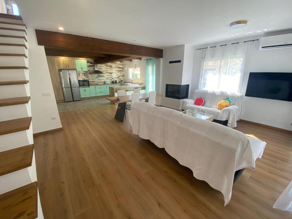 a living room with tables and a couch and a kitchen at Casa Libélula in Castelló d'Empúries