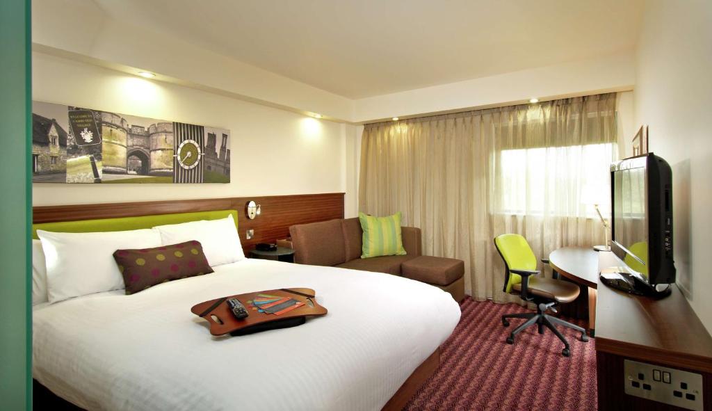 a hotel room with a bed with a bag on it at Hampton by Hilton Liverpool John Lennon Airport in Speke