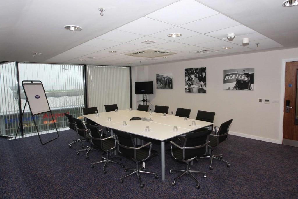 a conference room with a large white table and chairs at Hampton by Hilton Liverpool John Lennon Airport in Speke