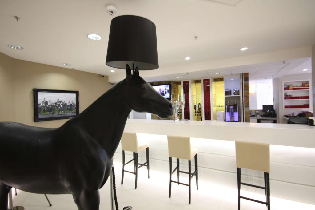 a statue of a horse standing in front of a bar at Hampton by Hilton Liverpool John Lennon Airport in Speke