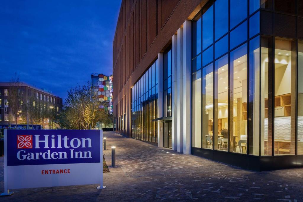 un edificio con un millón de letreros de posada en el jardín delante de él en Hilton Garden Inn Stoke On Trent, en Stoke on Trent