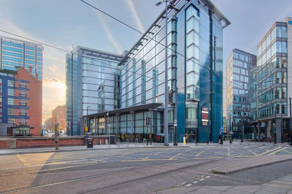 a city street with a large glass building at DoubleTree by Hilton Manchester Piccadilly in Manchester